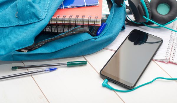 School bag with books, pens and cell phone